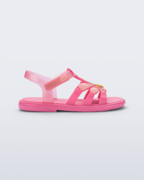 Side view of a glitter pink Hip Bloomy kids sandal with pink daisy on top