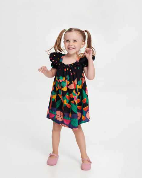 Child model in a dress wearing a pair of milky pink Soft Ballerina baby flats