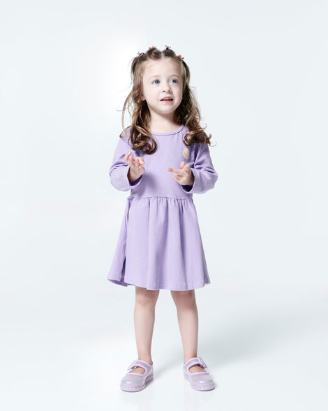 Child model in a purple dress wearing a pair of pearly lilac Hip Ballerina flats
