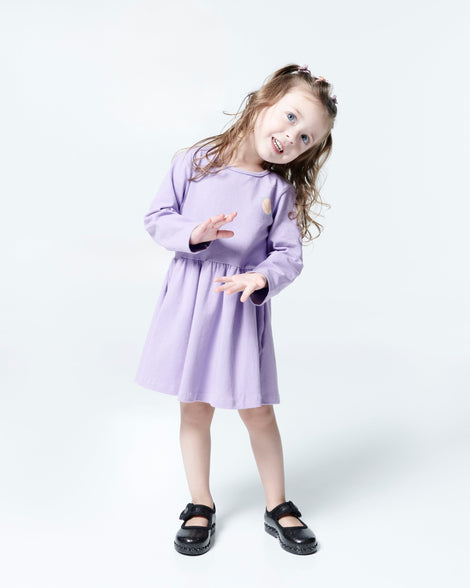 Child model in a purple dress wearing a pair of black Hip Ballerina flats