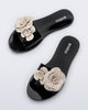 Top view of a pair of black Babe Petals slide with beige flowers on top