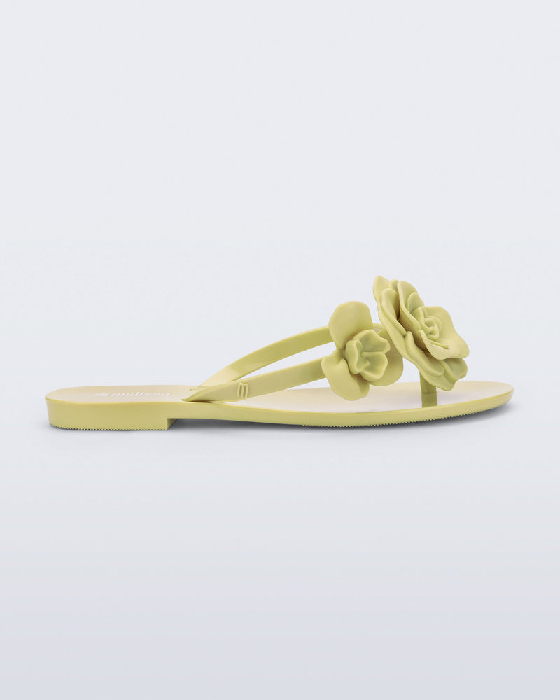 Side view of a green Harmonic Petals flip Flop with green flowers on top