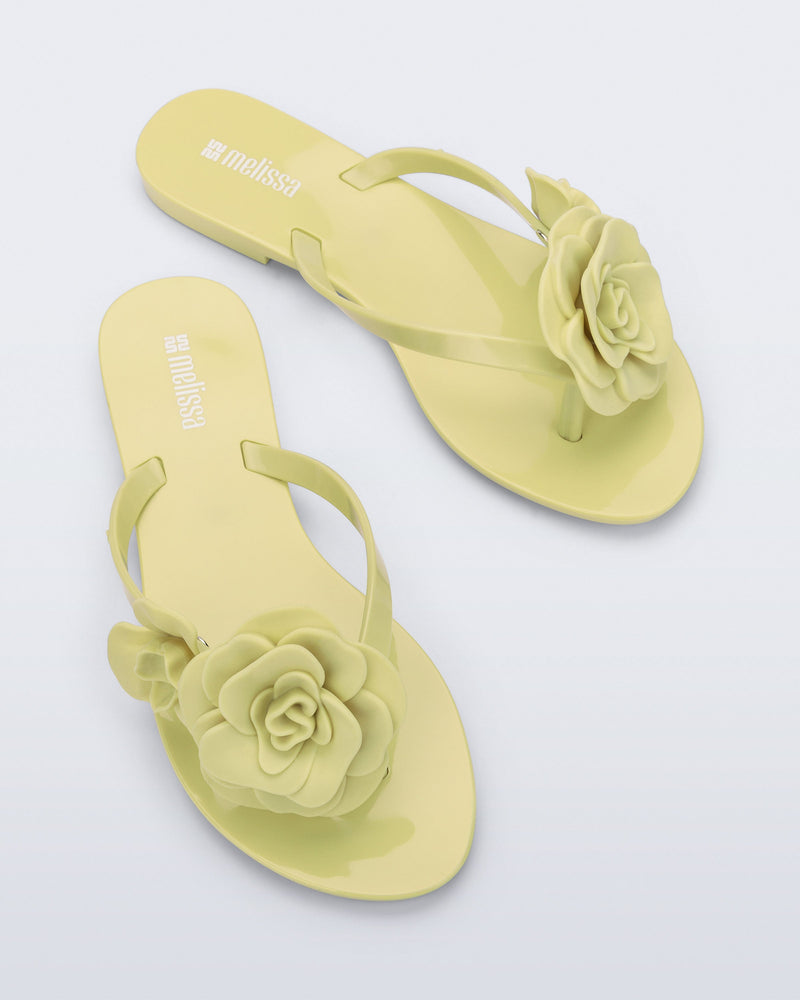 Top view of a pair of green Harmonic Petals flip Flop with green flowers on top