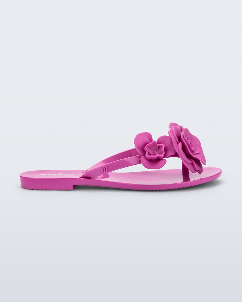 Side view of a pink Harmonic Petals flip Flop with pink flowers on top