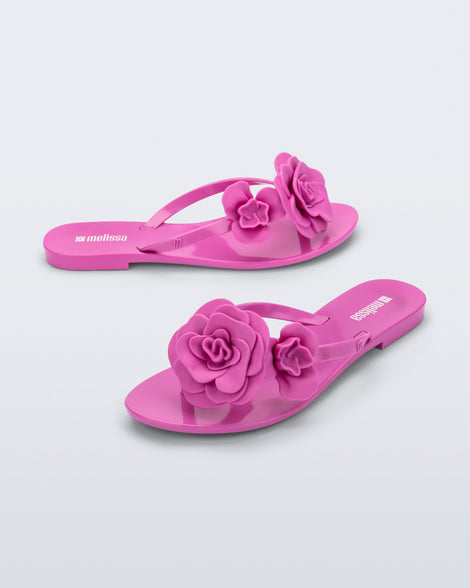 Side and angled view of a pair of pink Harmonic Petals flip Flop with pink flowers on top