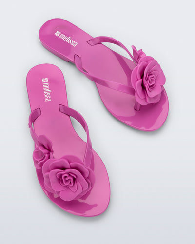 Top view of a pair of pink Harmonic Petals flip Flop with pink flowers on top