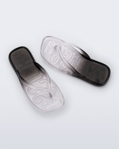 Top view of a pair of black/clear Beachwear flip flops