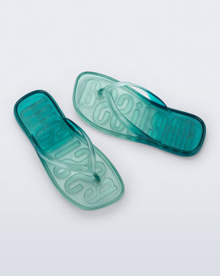 Top view of a pair of green/blue Beachwear flip flops