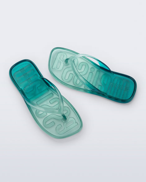 Top view of a pair of green/blue Beachwear flip flops