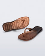 Top and angled view of a pair of brown/black Beachwear flip flops