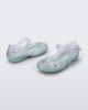 Back and side angled view of a pair of clear Melissa + Susan Fang Luna Bloom flats with flower adornments and misty green sole