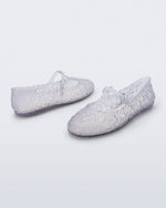 Back and side angled view of a pair of clear Melissa + Susan Fang Daphnis Ballerinas with t-top strap