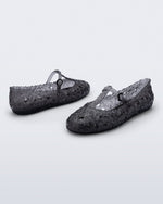 Back and side angled view of a pair of clear black Melissa + Susan Fang Daphnis Ballerinas with t-top strap