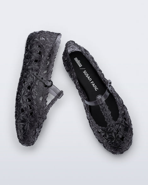 Top and side view of a pair of clear black Melissa + Susan Fang Daphnis Ballerinas with t-top strap