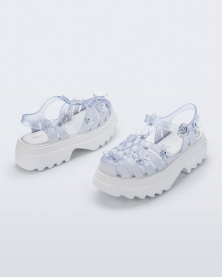 Back and side angled view of a pair of Clear Melissa + Susan Fang Possession Platform Sakura sandals with white soles