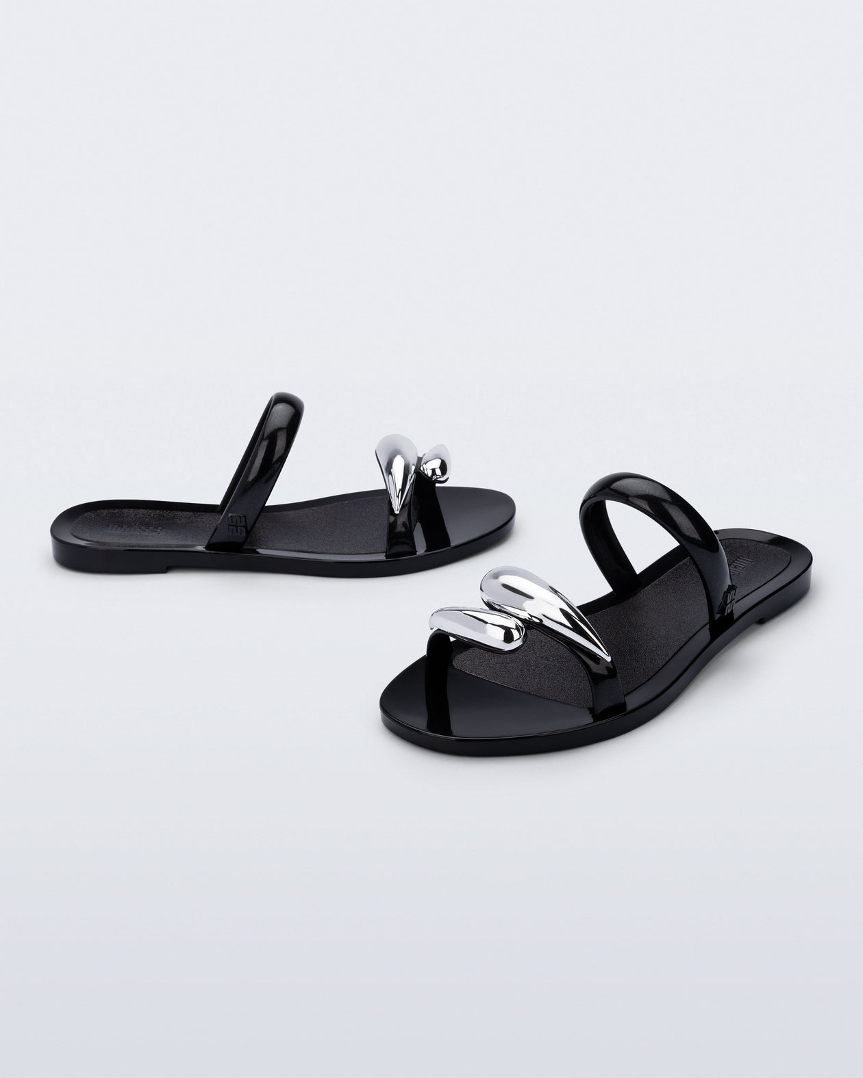 Side and angled view of a pair of black Eden sandals with metallic straps