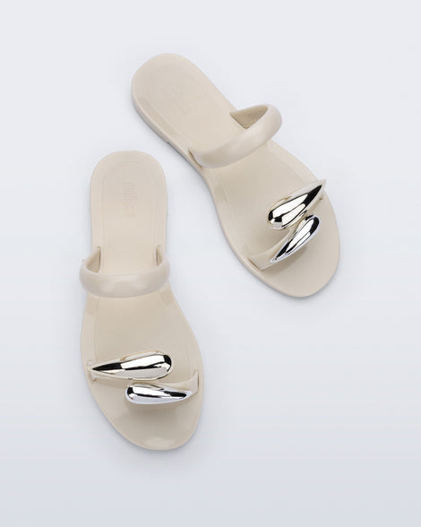 Top view of a pair of beige Eden sandals with metallic straps