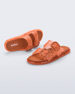 Top and side view of a pair of orange Possession Slip sandals with two straps with buckles
