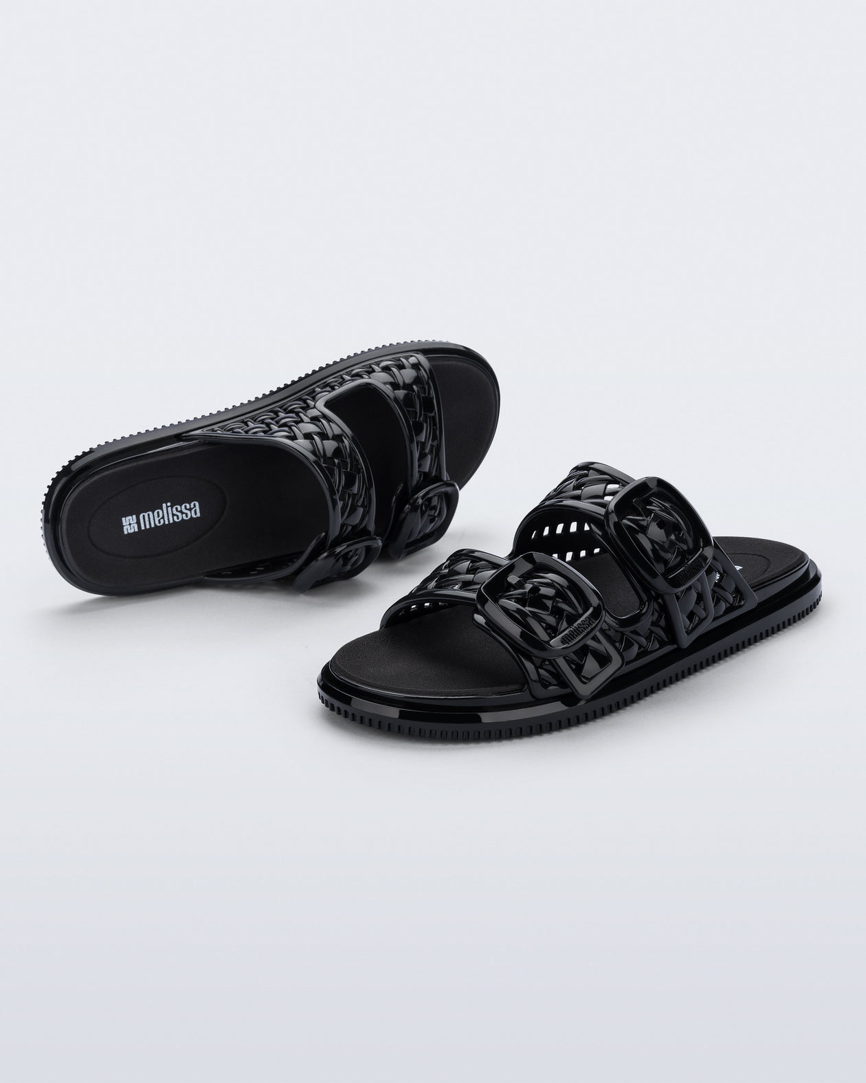 Top and side view of a pair of black Possession Slip sandals with two straps with buckles