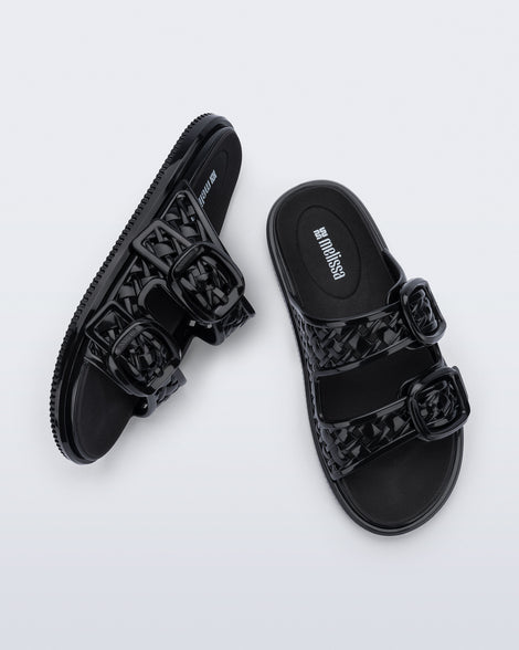 Top and side view of a pair of black Possession Slip sandals with two straps with buckles