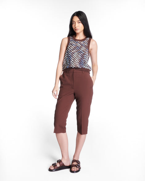 Model in brown pants and patterned shirt wearing a pair of brown Possession Slip sandals with two straps with buckles