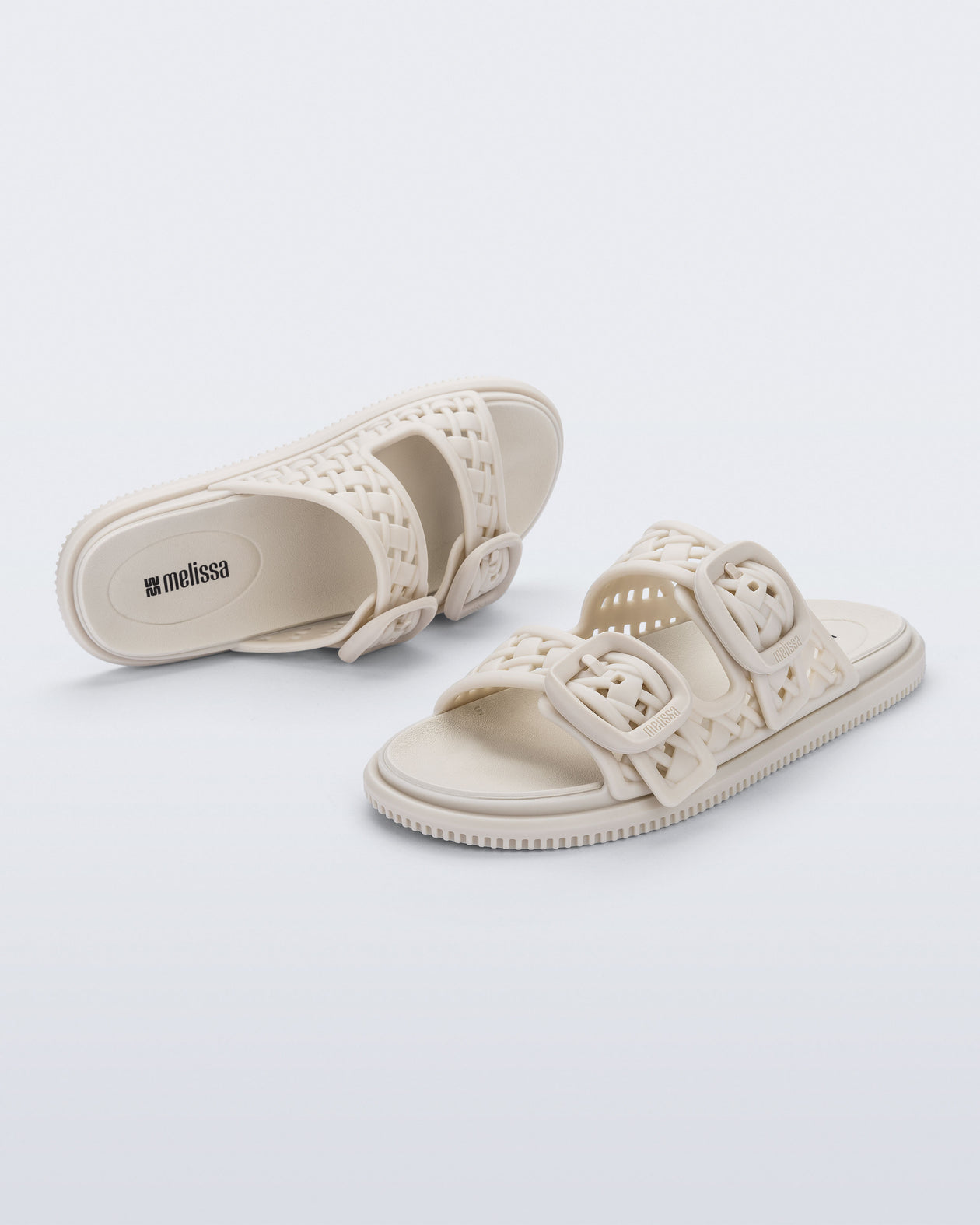 Top and side view of a pair of beige Possession Slip sandals with two straps with buckles
