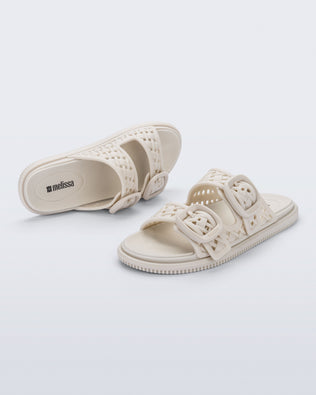 Top and side view of a pair of beige Possession Slip sandals with two straps with buckles
