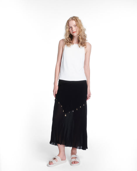 Model in a white shirt and black skirt wearing a pair of beige Possession Slip sandals with two straps with buckles