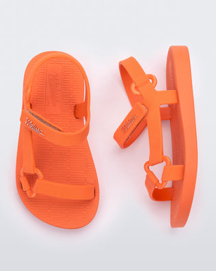 Top and side view of a pair of orange Sun Downtown baby sandals