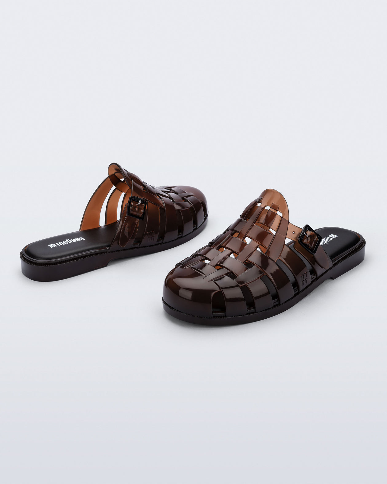 Side and back angled view of a pair of brown Possession Mule slides 