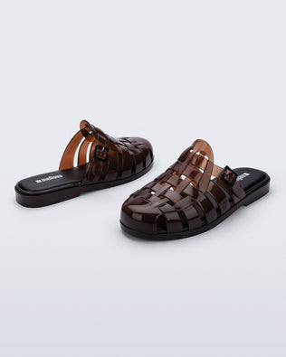 Side and back angled view of a pair of brown Possession Mule slides 