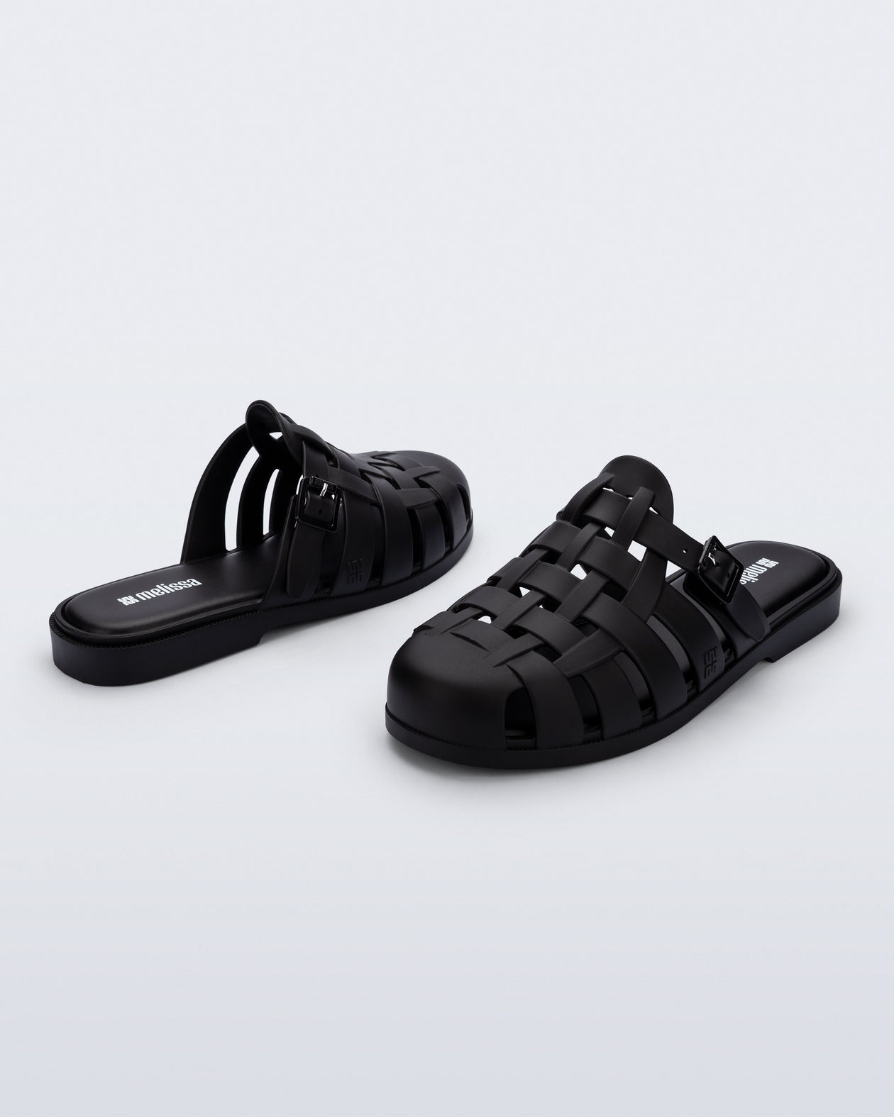 Side and back angled view of a pair of matte black Possession Mule slides 