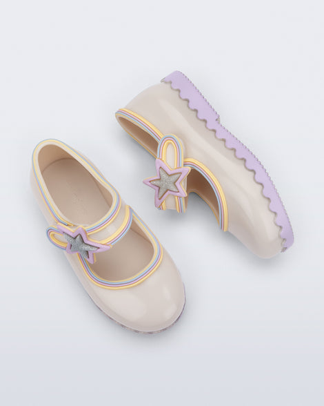 Side and top view of a pair of beige Hip Ballerina Star baby Mary Jane shoes with lavender soles and star-shaped straps