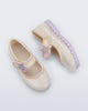 Side and top view of a pair of beige Hip Ballerina Star baby Mary Jane shoes with lavender soles and star-shaped straps