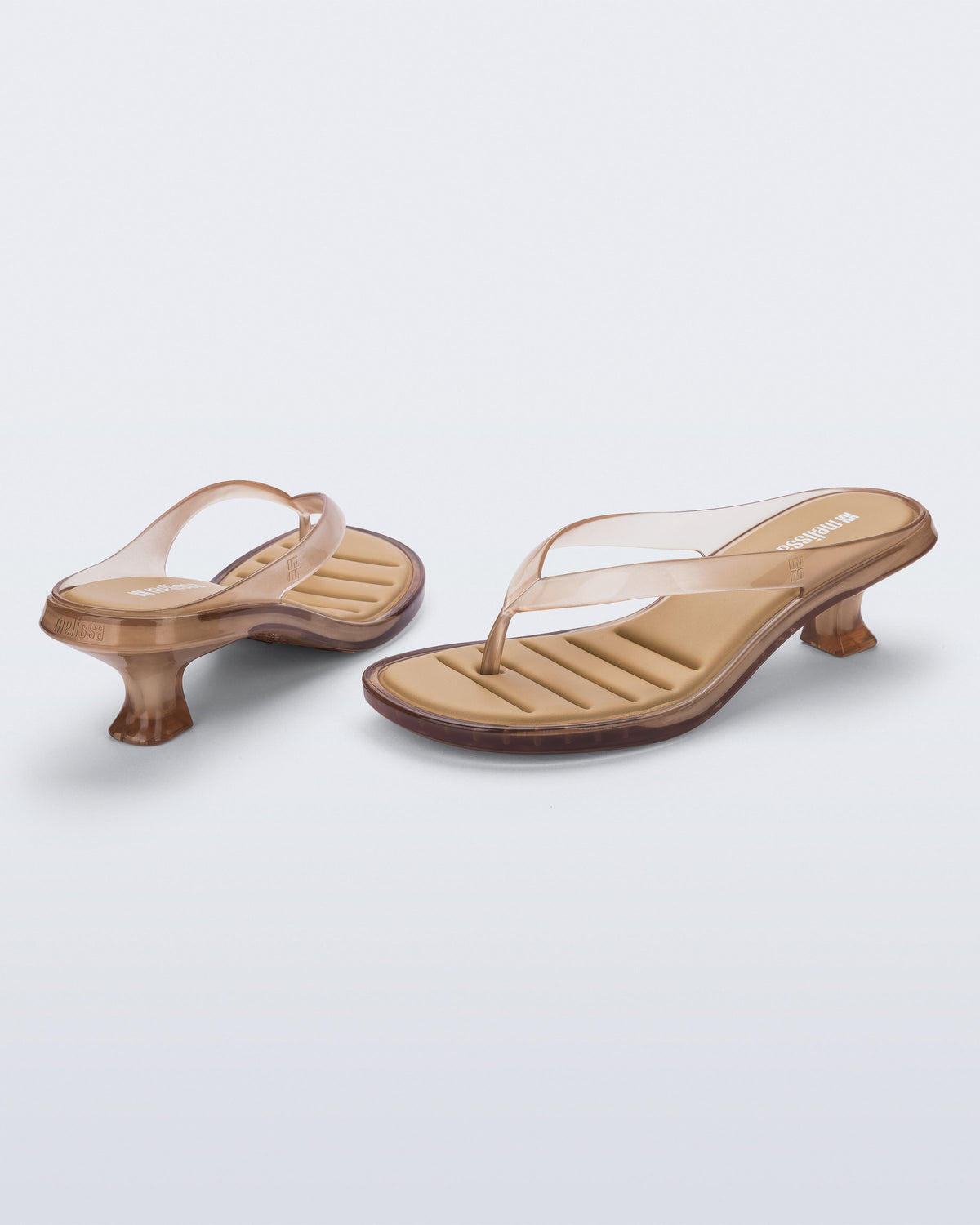Back and angled view of a pair of clear beige Flip Flop Kitten Heels