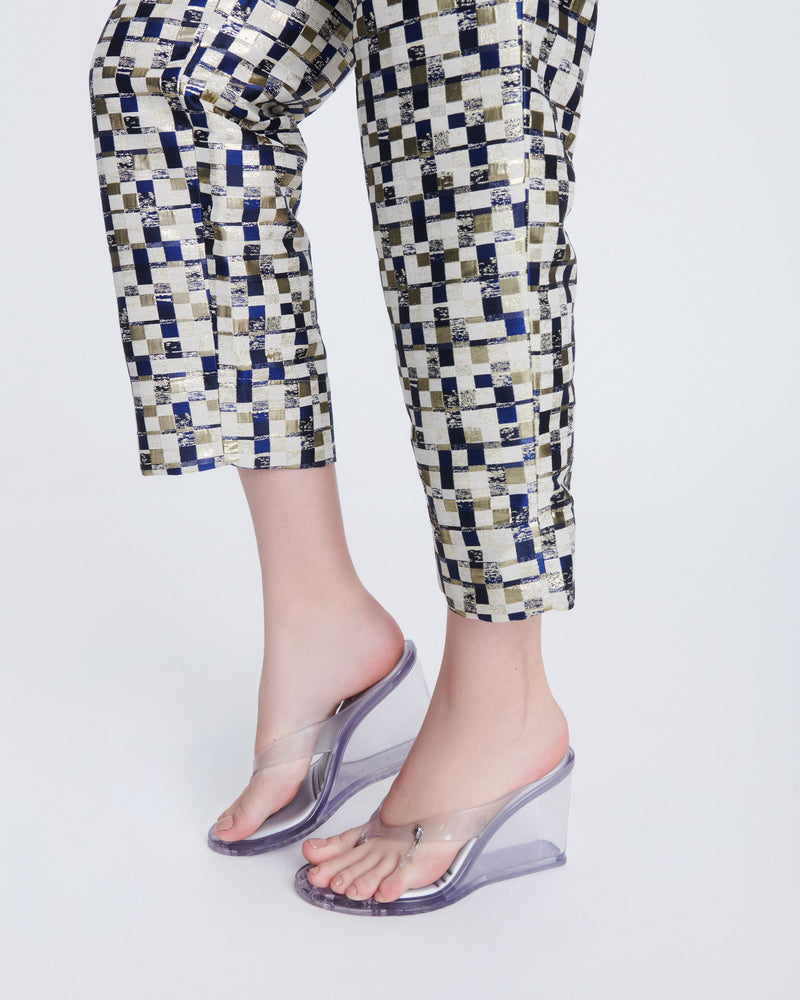 model's legs in a black and white pant suit wearing a pair of clear/white Nabeela heel wedge shoes