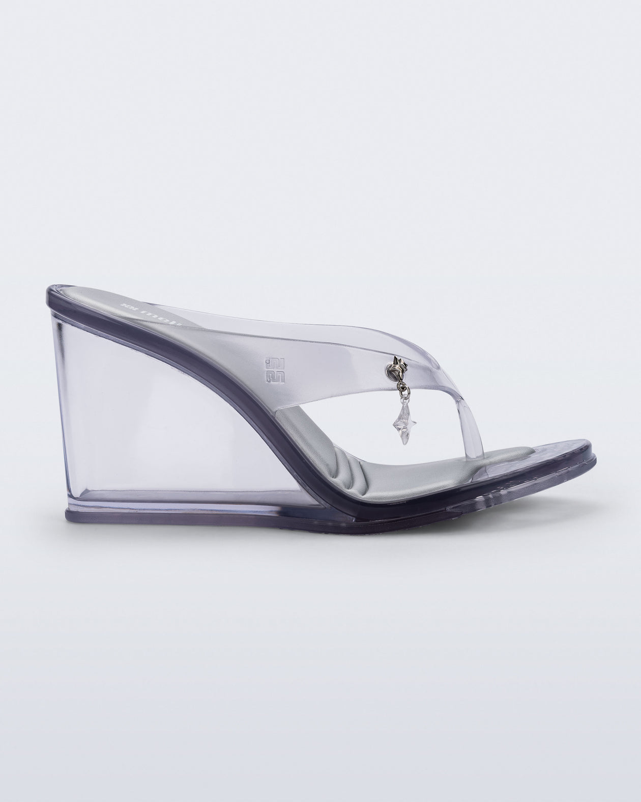 Side view of a clear grey Nabeela wedge flip flop with star charm on the strap