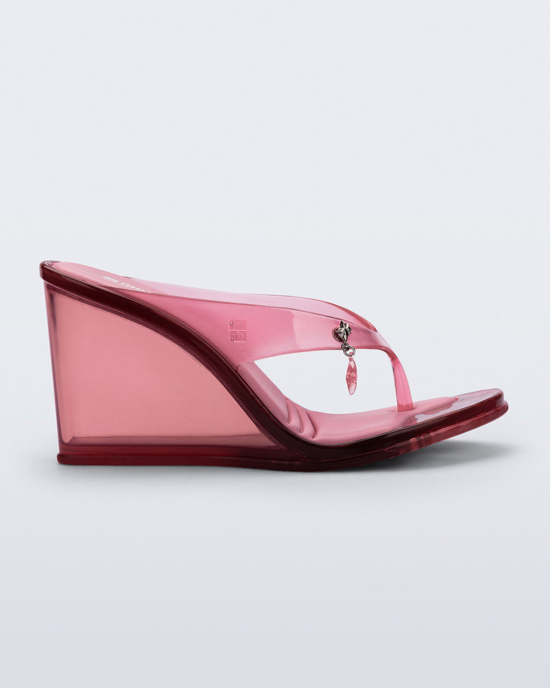 Side view of a pink Nabeela wedge flip flop with star charm on the strap