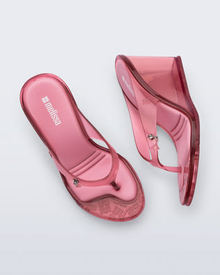Top and side view of a pair of pink Nabeela wedge flip flops with star charm on strap