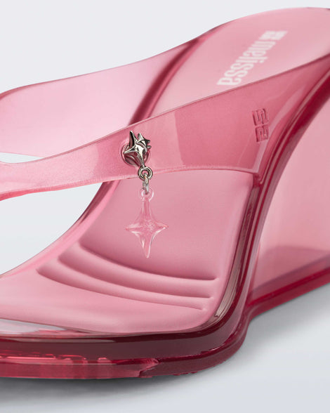 Close up of the star charm on the pink Nabeela wedge flip flop