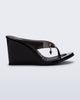 Side view of a black Nabeela wedge flip flop with star charm on strap