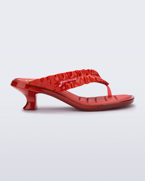 side view of a red Flip Flop Kitten Heel + GANNI sandal with cherry print foot bed and faux ruffle strap