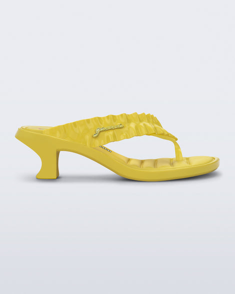 Side view of a yellow Flip Flop Kitten Heel + GANNI sandal with cherry print foot bed and faux ruffle strap