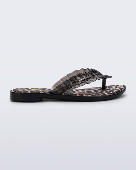 Side view of a black Flip Flop Slim+ GANNI sandals with leopard print foot bed and faux ruffle strap