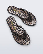 Top view of a pair of black Flip Flop Slim + GANNI sandals with leopard print foot bed and faux ruffle strap