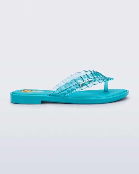 Side view of a blue Flip Flop Slim + GANNI sandals with a banana print foot bed and faux ruffle strap