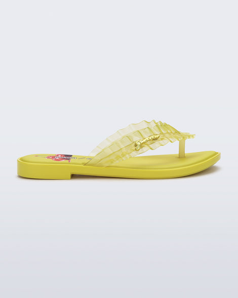 Side view of a yellow Flip Flop Slim + GANNI sandals with a cherry print foot bed and faux ruffle strap