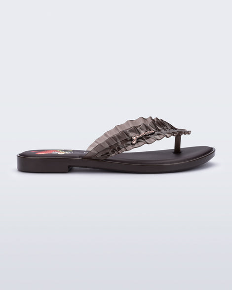 Side view of a brown Flip Flop Slim + GANNI sandals with a strawberry print foot bed and faux ruffle strap