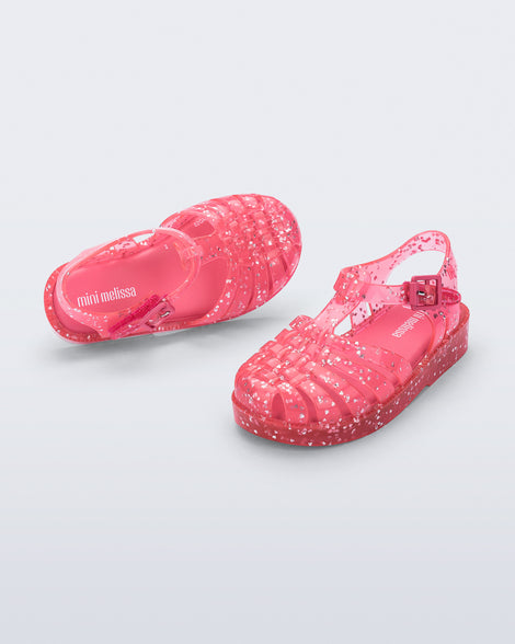 Top and angled view of a pair of pink Possession Elements baby sandal with glitter hearts
