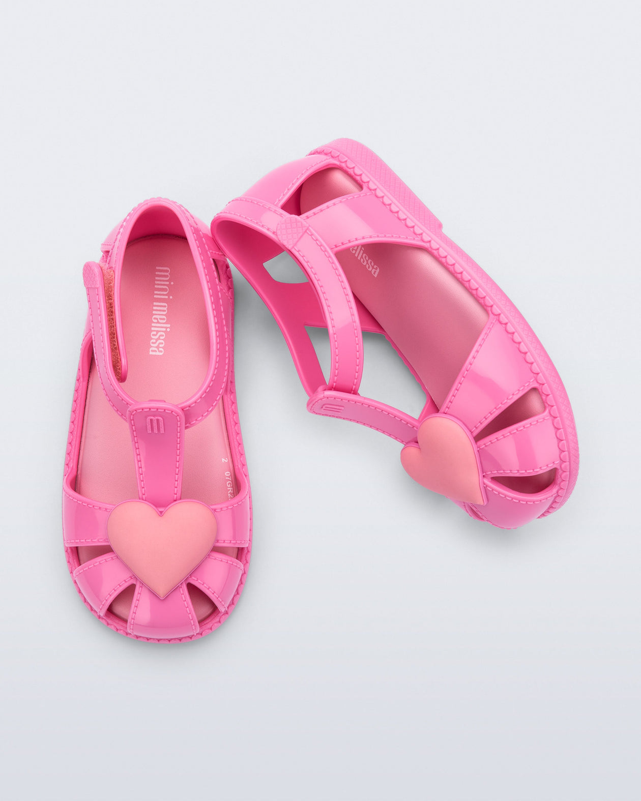 Side and top view of a pair of pink Hip Heart Ballerina baby sandals with heart on front